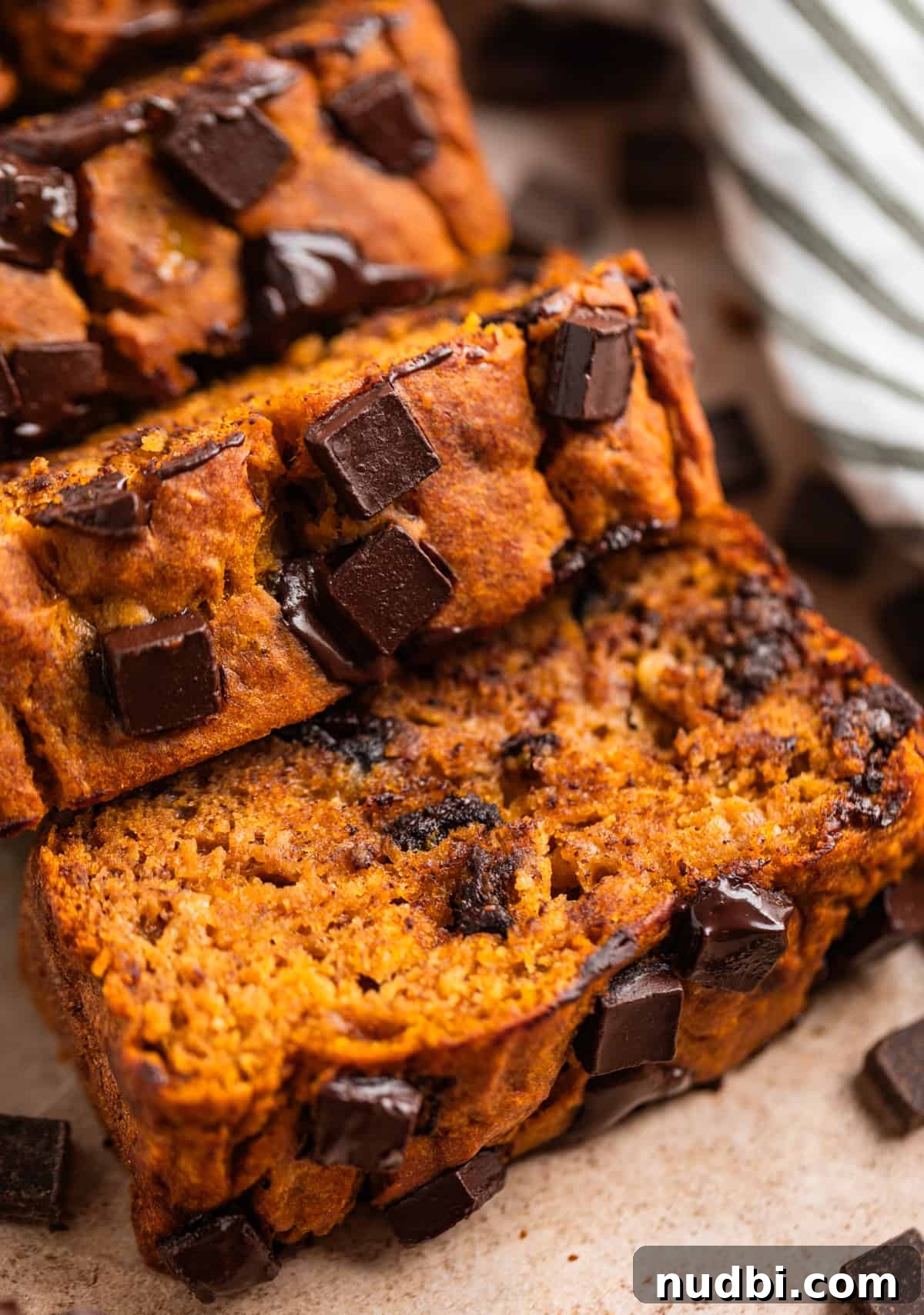 Pumpkin Chocolate Chip Banana Bread Recipe 7 Sliced of banana bread with dark chocolate chips layered at a slant.