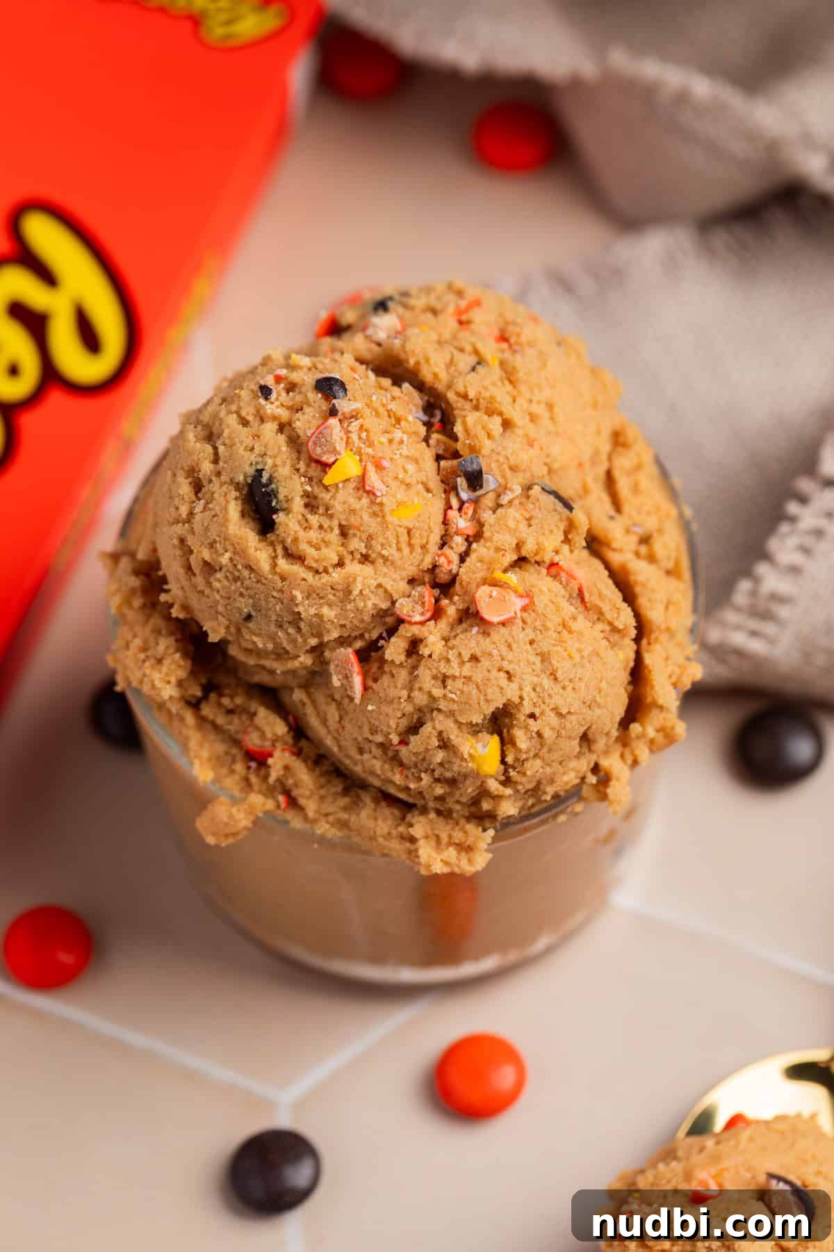 Edible Peanut Butter Cookie Dough Recipe for Safe Snacking 2 Edible peanut butter cookie dough with crushed reeses pieces scooped into glass cup.