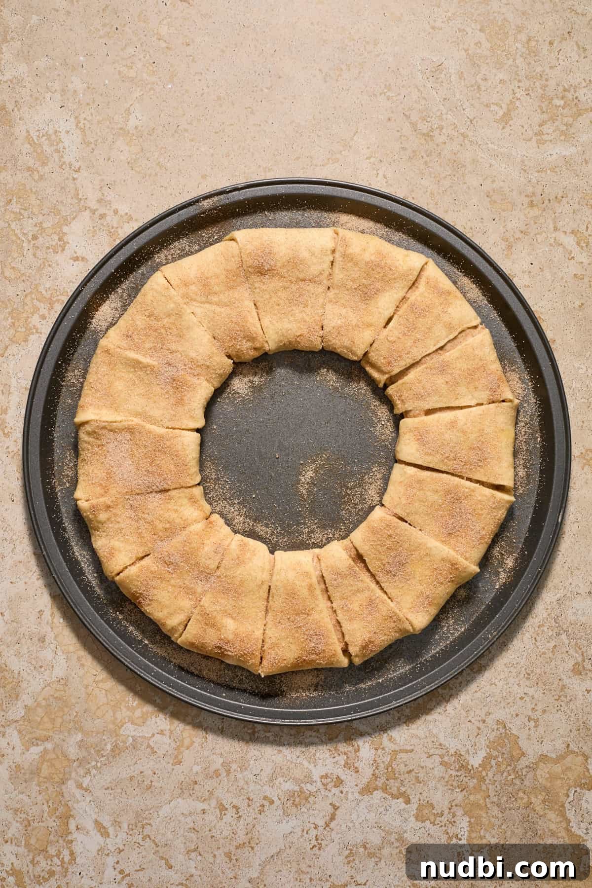 Cinnamon Crescent Roll Wreath Recipe — Festive Holiday Pastry 11 Cinnamon and sugar sprinkled over top of dough formed into circle.