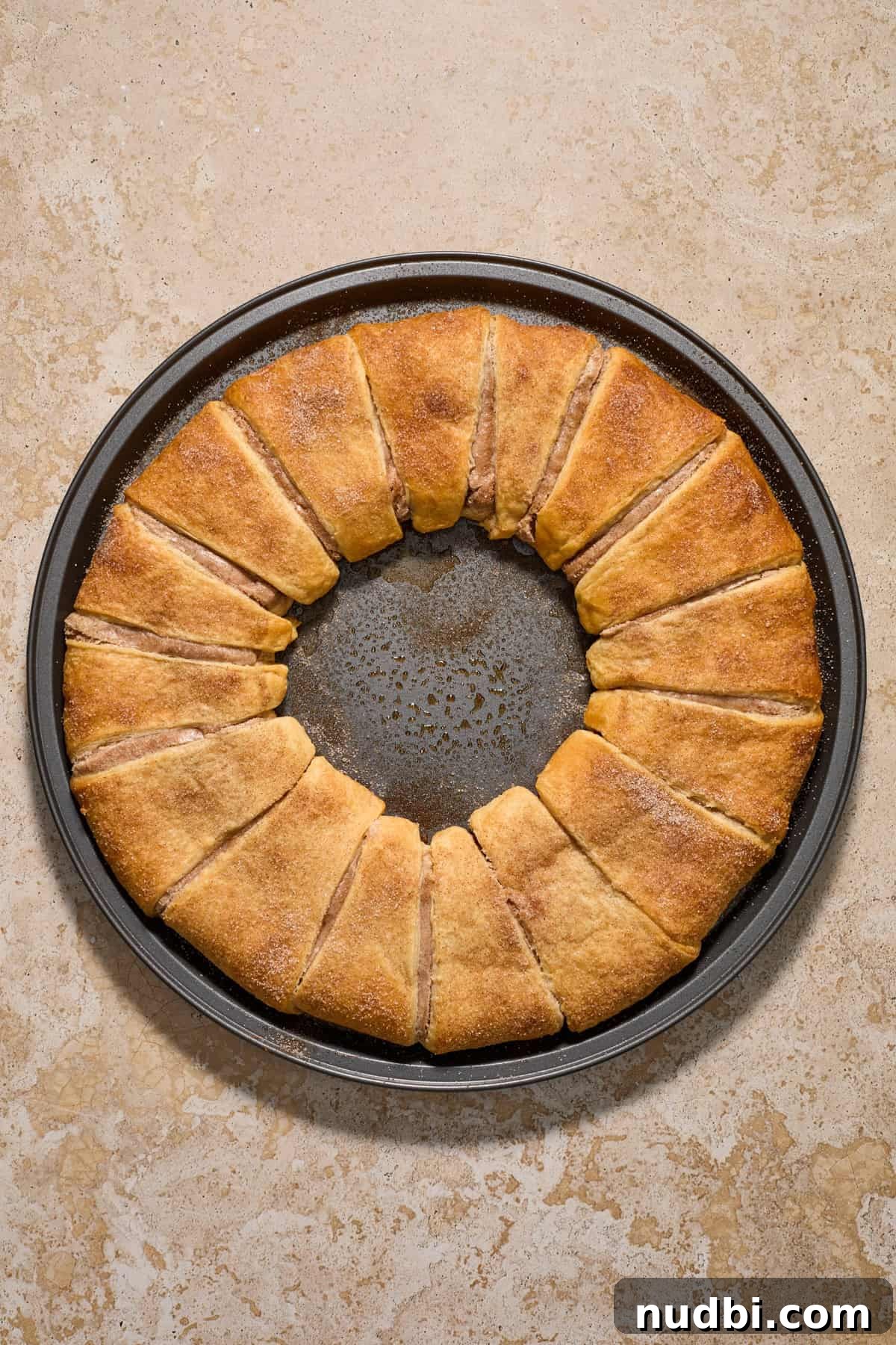 Cinnamon Crescent Roll Wreath Recipe — Festive Holiday Pastry 12 Baked crescent roll wreath on pan.
