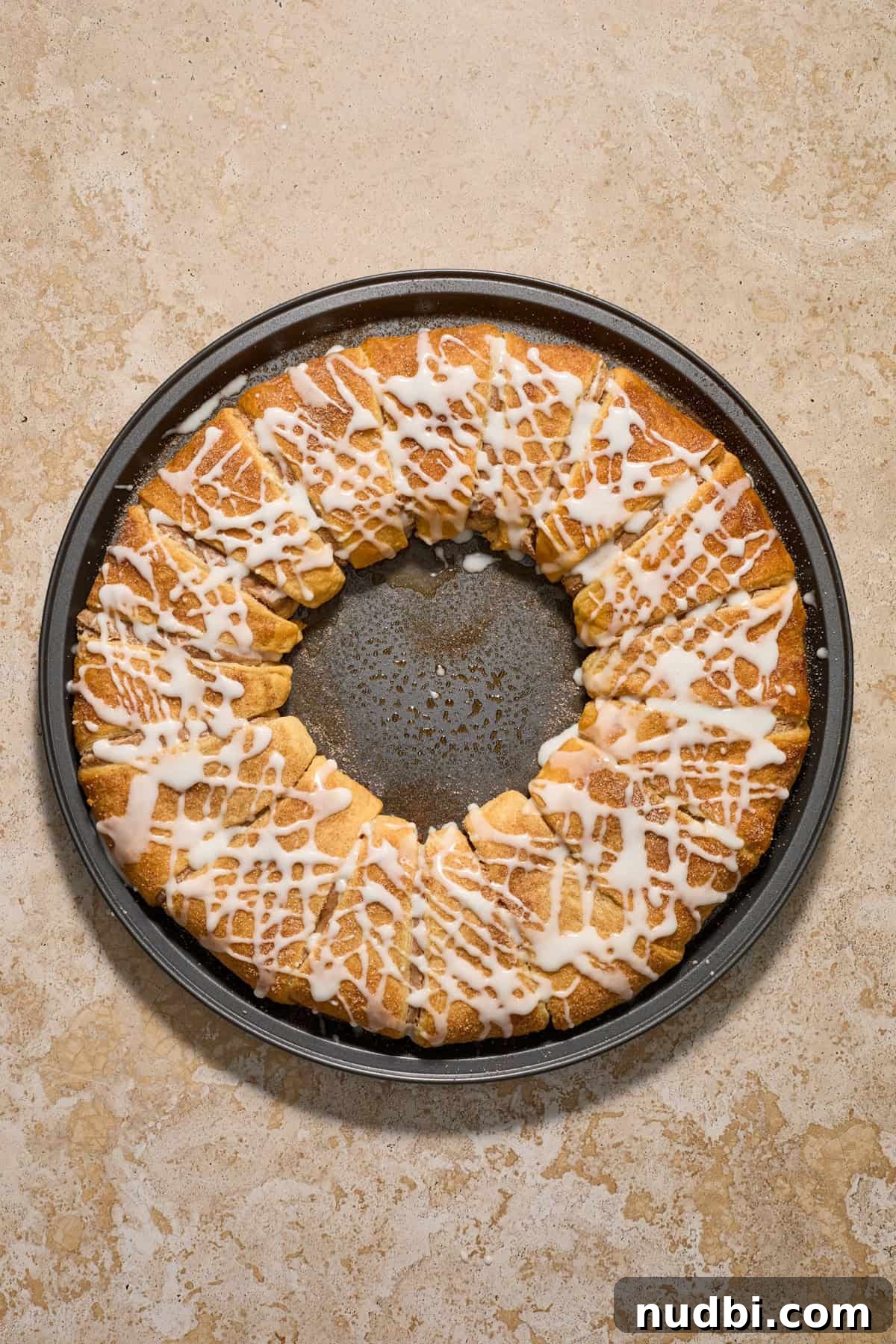 Cinnamon Crescent Roll Wreath Recipe — Festive Holiday Pastry 13 Baked cinnamon cream cheese pastry on pan freshly iced.