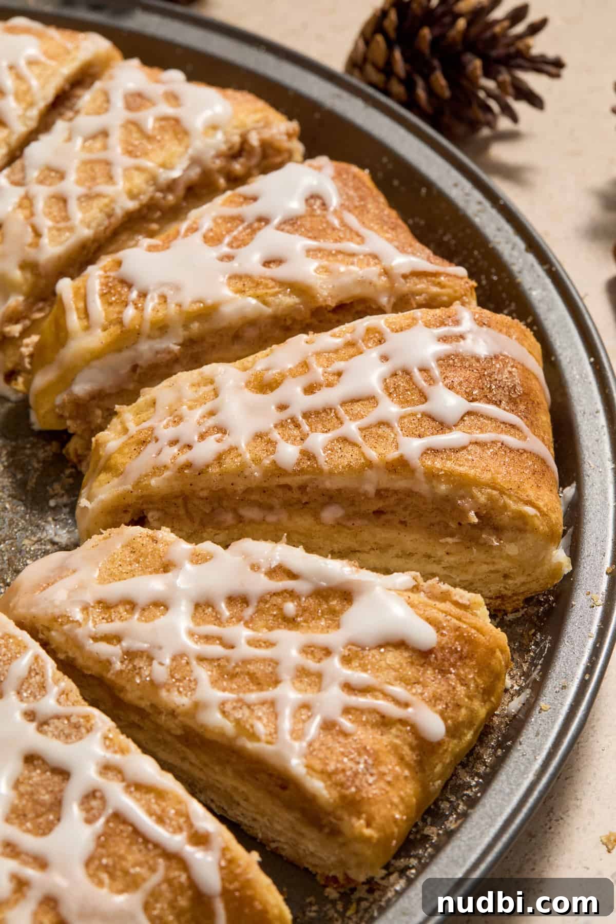 Cinnamon Crescent Roll Wreath Recipe — Festive Holiday Pastry 14 Slices of crescent roll wreath on pan with icing drizzle and cinnamon cream cheese filling.