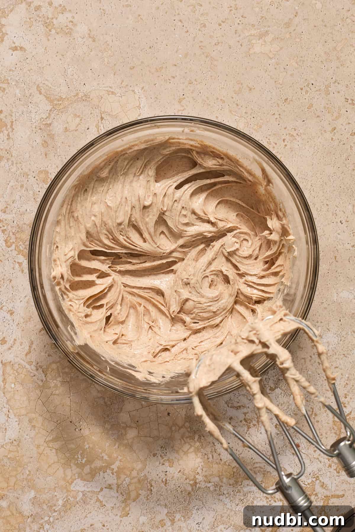 Cinnamon Crescent Roll Wreath Recipe — Festive Holiday Pastry 4 Creamed cream cheese and sugar in bowl with electric mixer propped to the side.