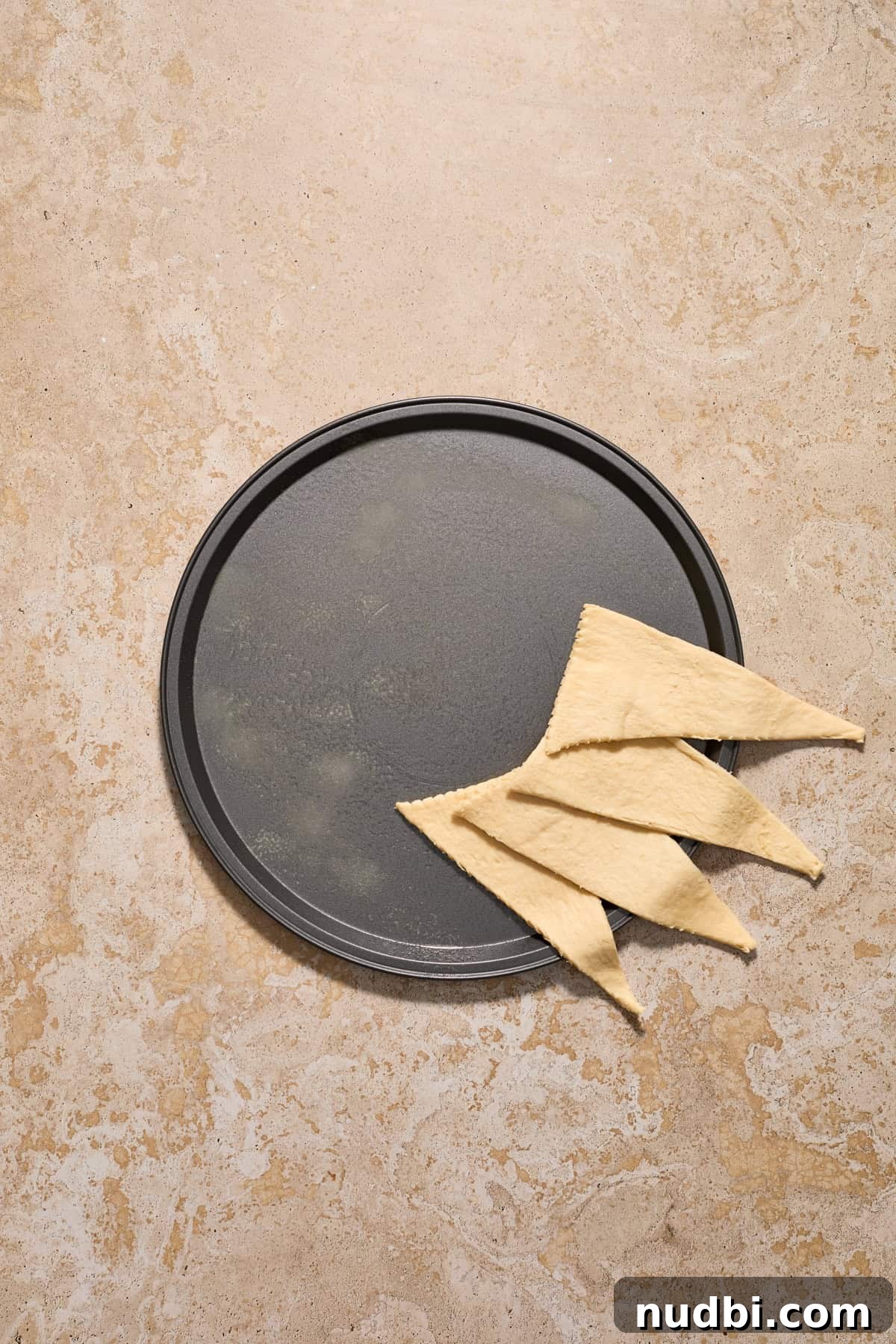 Cinnamon Crescent Roll Wreath Recipe — Festive Holiday Pastry 5 Crescent dough lined to start forming a circle on a pizza pan.