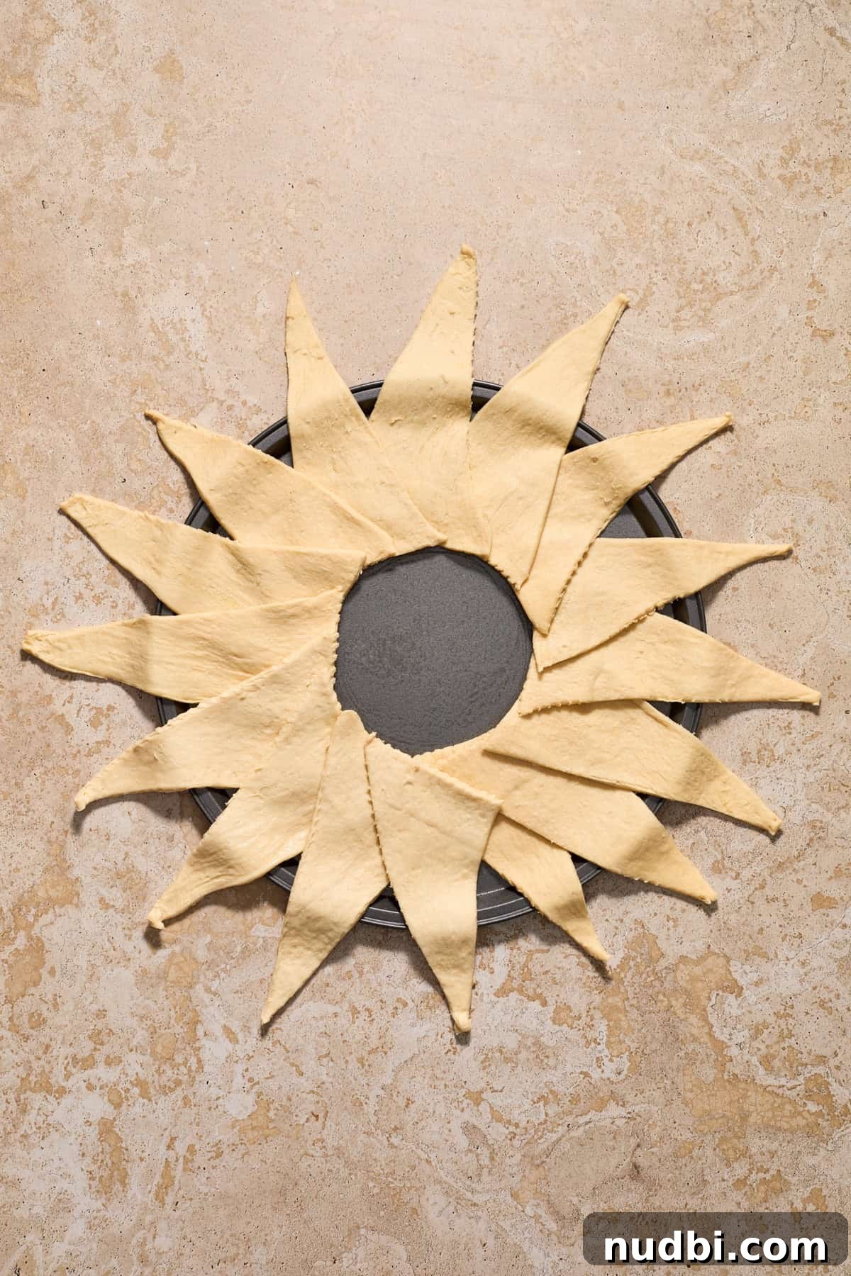 Cinnamon Crescent Roll Wreath Recipe — Festive Holiday Pastry 7 Crescent roll triangles arranged around a circular pan to form a full circle.