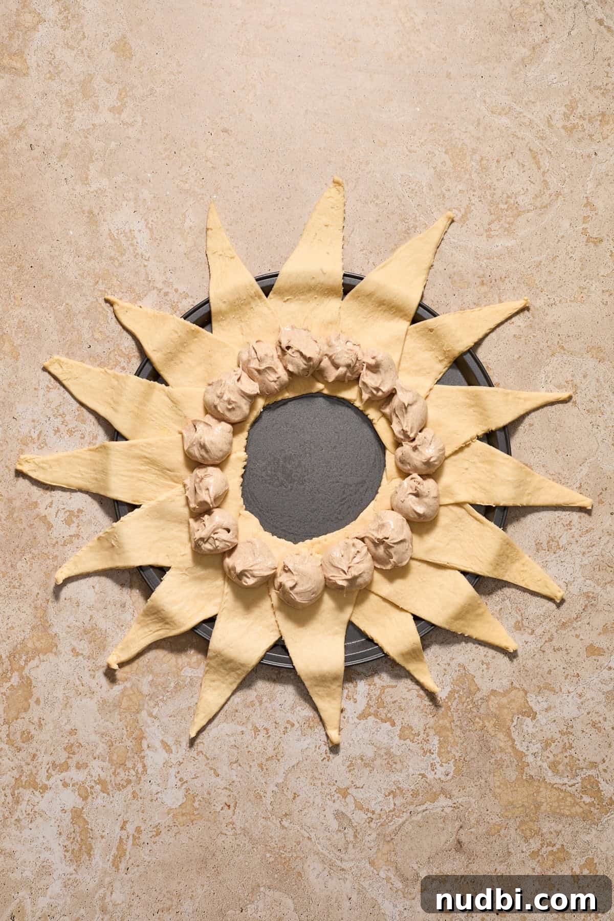Cinnamon Crescent Roll Wreath Recipe — Festive Holiday Pastry 8 Cinnamon cream cheese mixture spooned into the center of crescent triangles arranged to form a circle.