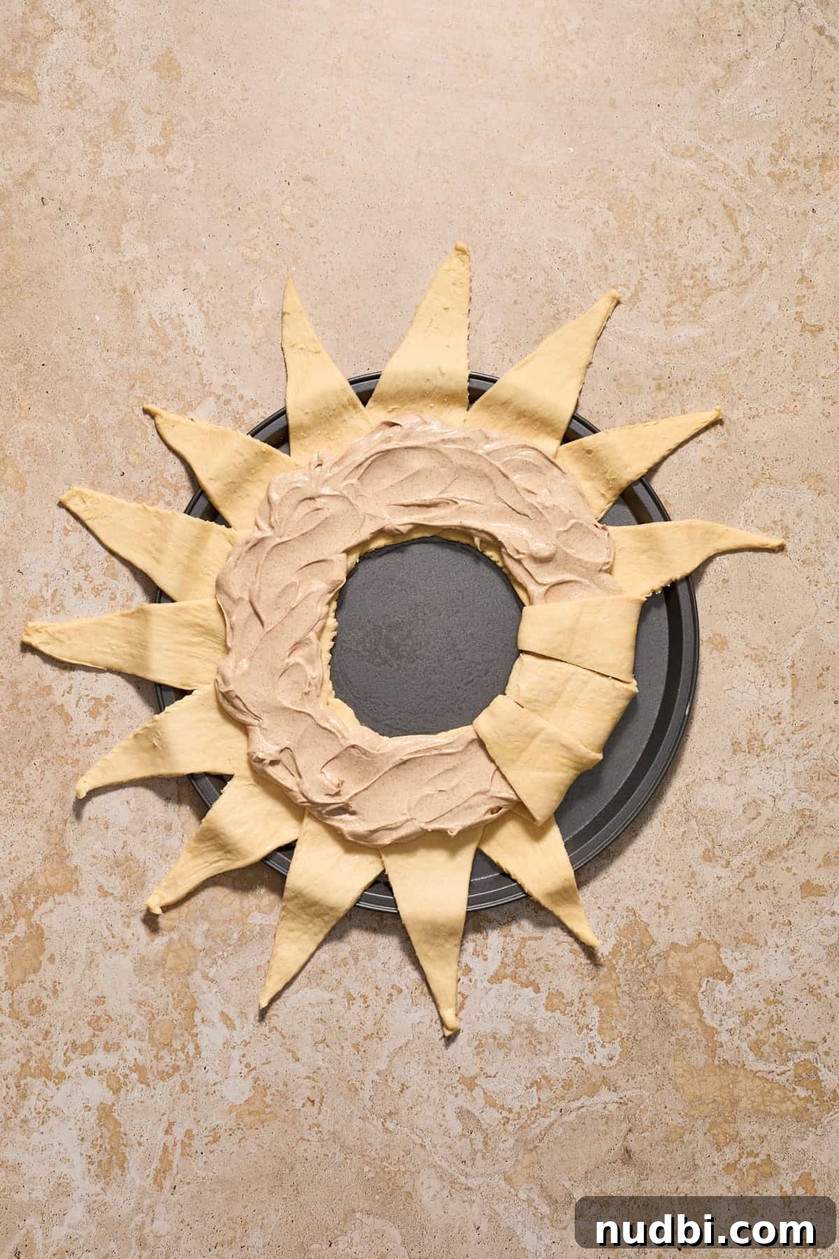 Cinnamon Crescent Roll Wreath Recipe — Festive Holiday Pastry 9 Cinnamon cream cheese mixture spread evenly and then several pieces of dough folded over the top.