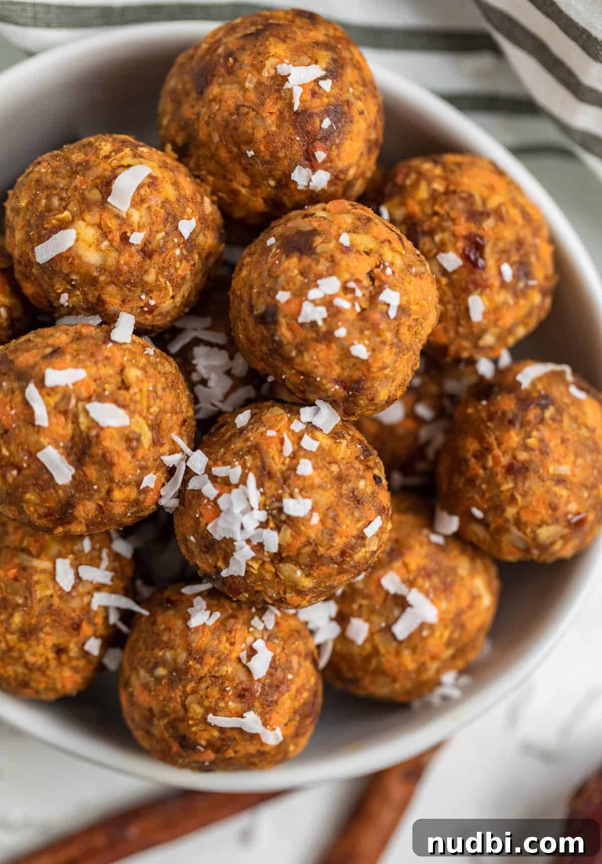Carrot Cake Bites Recipe: Moist Mini Carrot Cake Balls 3 Bowl of carrot cake balls with shredded coconut on top.