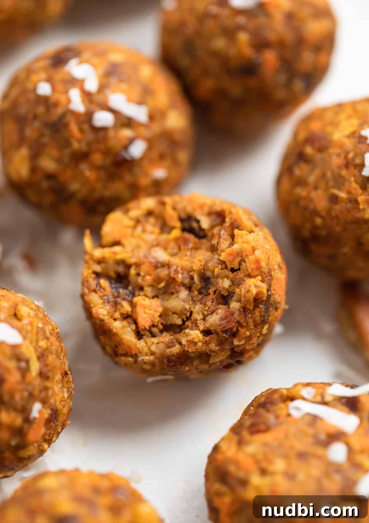 Carrot Cake Bites Recipe: Moist Mini Carrot Cake Balls 8 Bite shot of no bake carrot cake bites on counter.