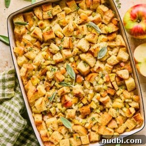 Apple and Sage Stuffing with Cranberries and Pecans 19 Pan with apple stuffing topped with herbs.