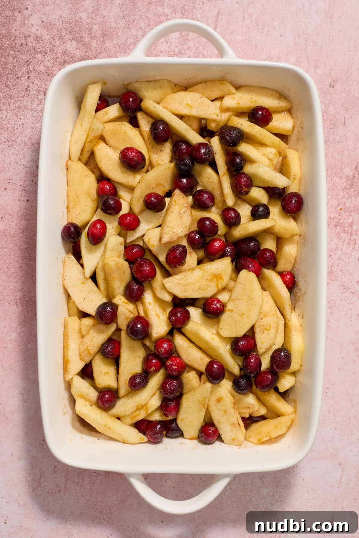 Cranberry Apple Crisp Recipe — Tart & Spiced Autumn Dessert 6 Baking dish with cranberries, apples, sugar and spices tossed together.