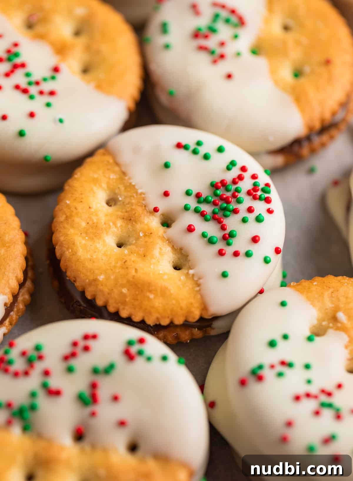 White Chocolate-Dipped Nutella Ritz Cracker Cookies 2 Nutella Ritz cracker cookies dipped in white chocolate arranged on parchment paper.