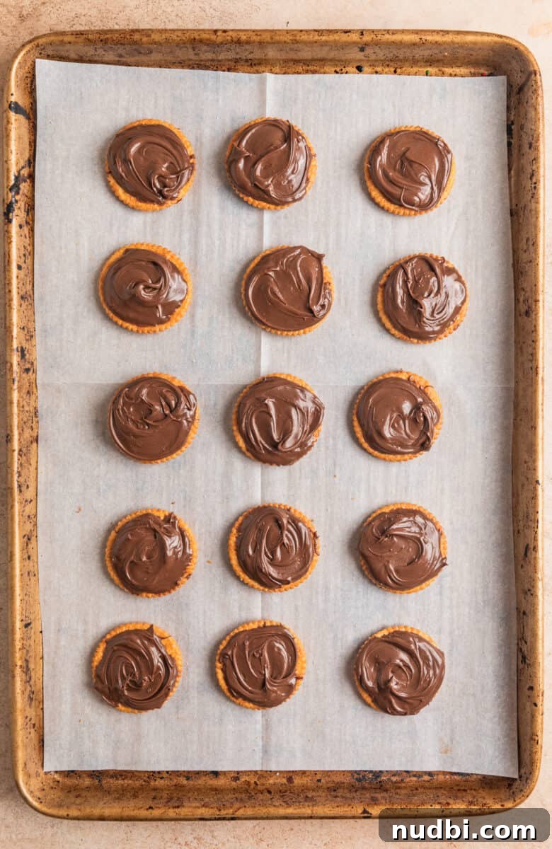 White Chocolate-Dipped Nutella Ritz Cracker Cookies 6 Nutella spread on Ritz crackers arranged on cookie sheet.