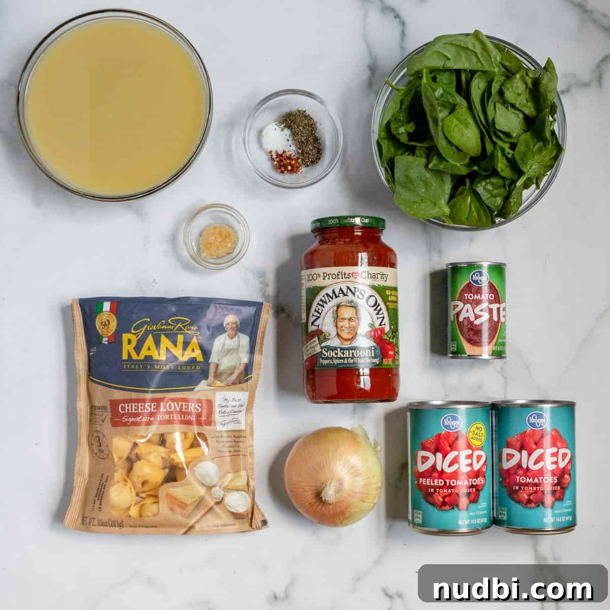Creamy Tomato Tortellini Soup Recipe for Cozy Dinners 3 Ingredients needed to make tomato tortellini soup including broth, spinach, canned tomatoes, and more on counter.