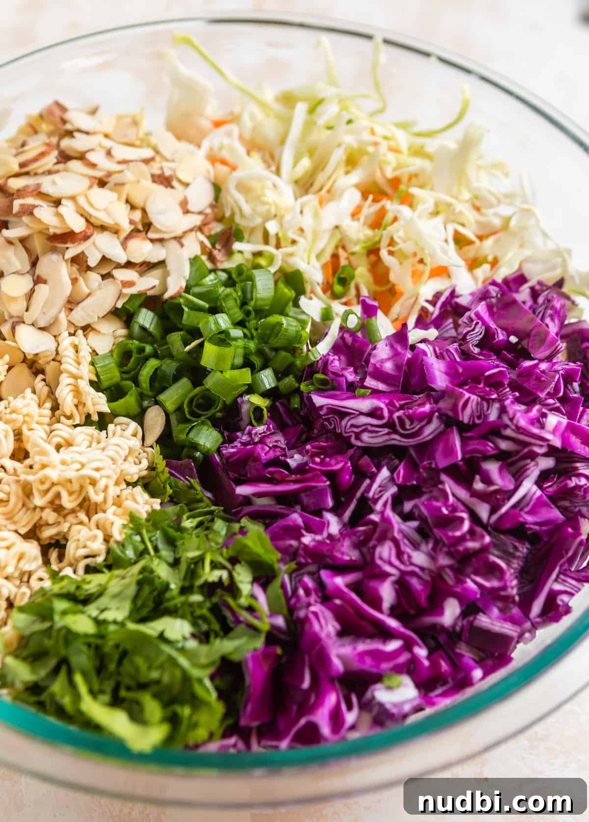 Crunchy Ramen Cabbage Salad with Creamy Peanut Dressing 3 Chopped cabbage, cole slaw mix, almonds, cilantro and cole slaw mix in mixing bowl.