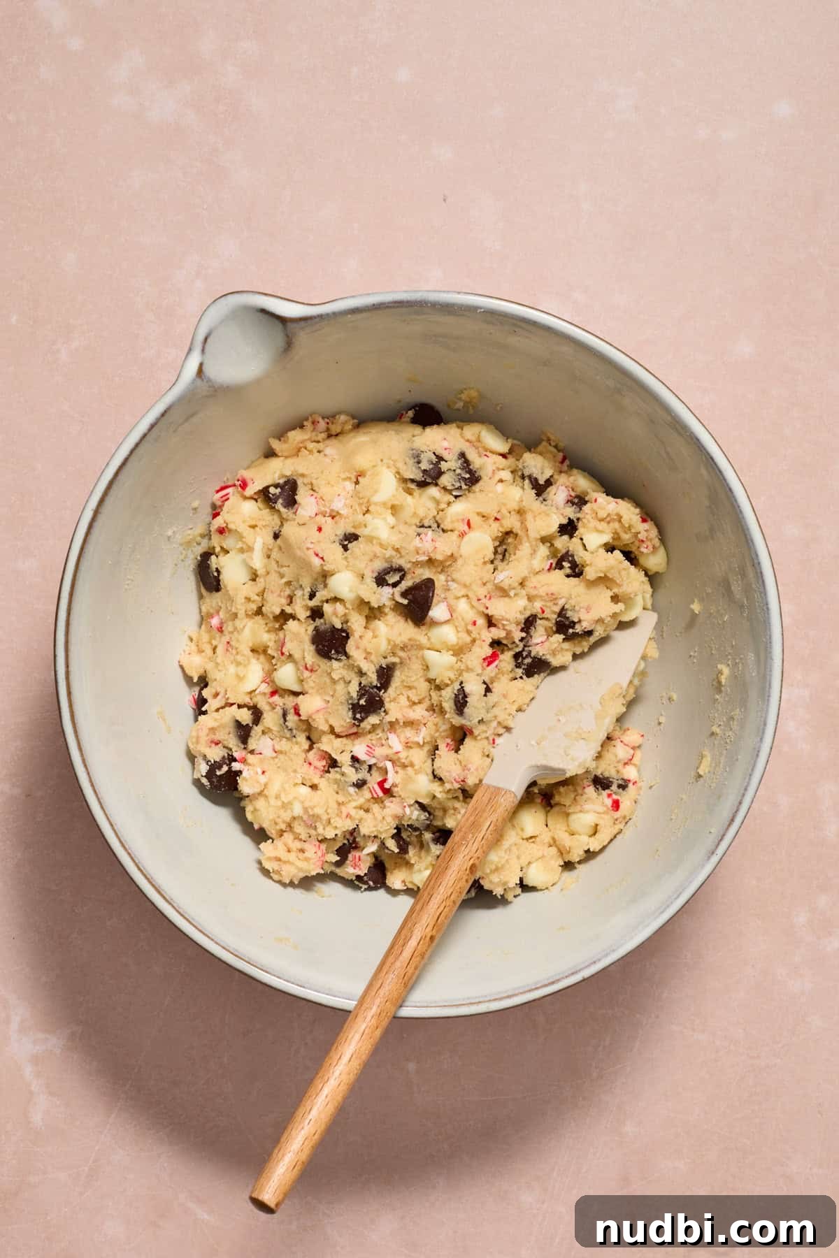 Peppermint Chocolate Chip Cookie Recipe: Festive Minty Cookies 12 Prepared chocolate chip peppermint cookie dough in bowl with spatula.