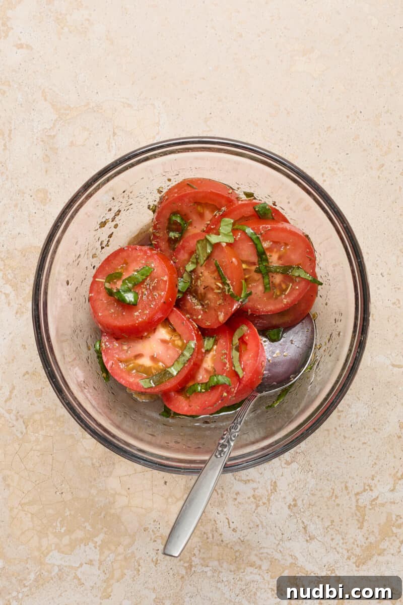 Cheesy Mozzarella-Stuffed Chicken Breast Recipe 5 Tomatoes and basil in olive oil and balsamic mixture in bowl.