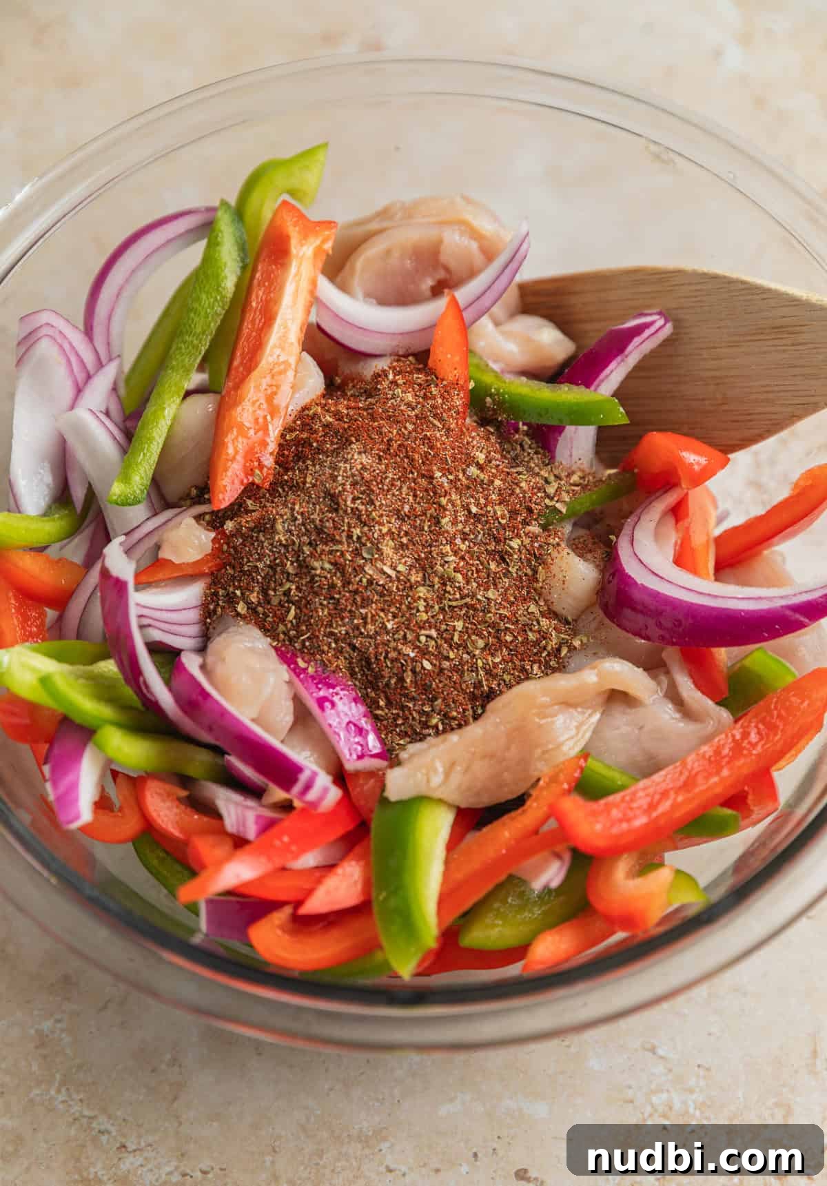 Honey-Lime Baked Chicken Fajitas Recipe for Flavorful Weeknights 5 Fajita seasoning and marinade ingredients added to bowl with chicken and veggies.