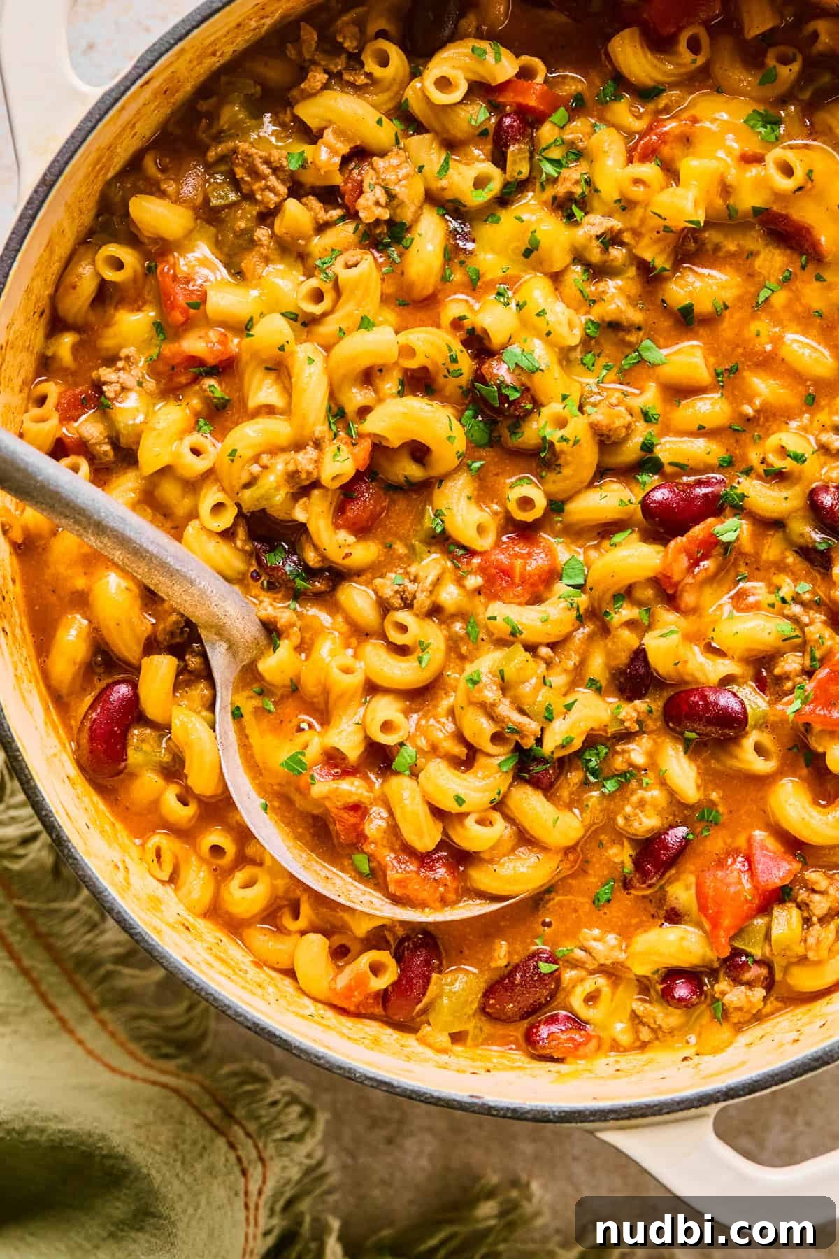 One-Pot Chili Mac: Cheesy Beef Skillet Dinner 2 Pot with chili mac and cheese and ladle scooping into it.