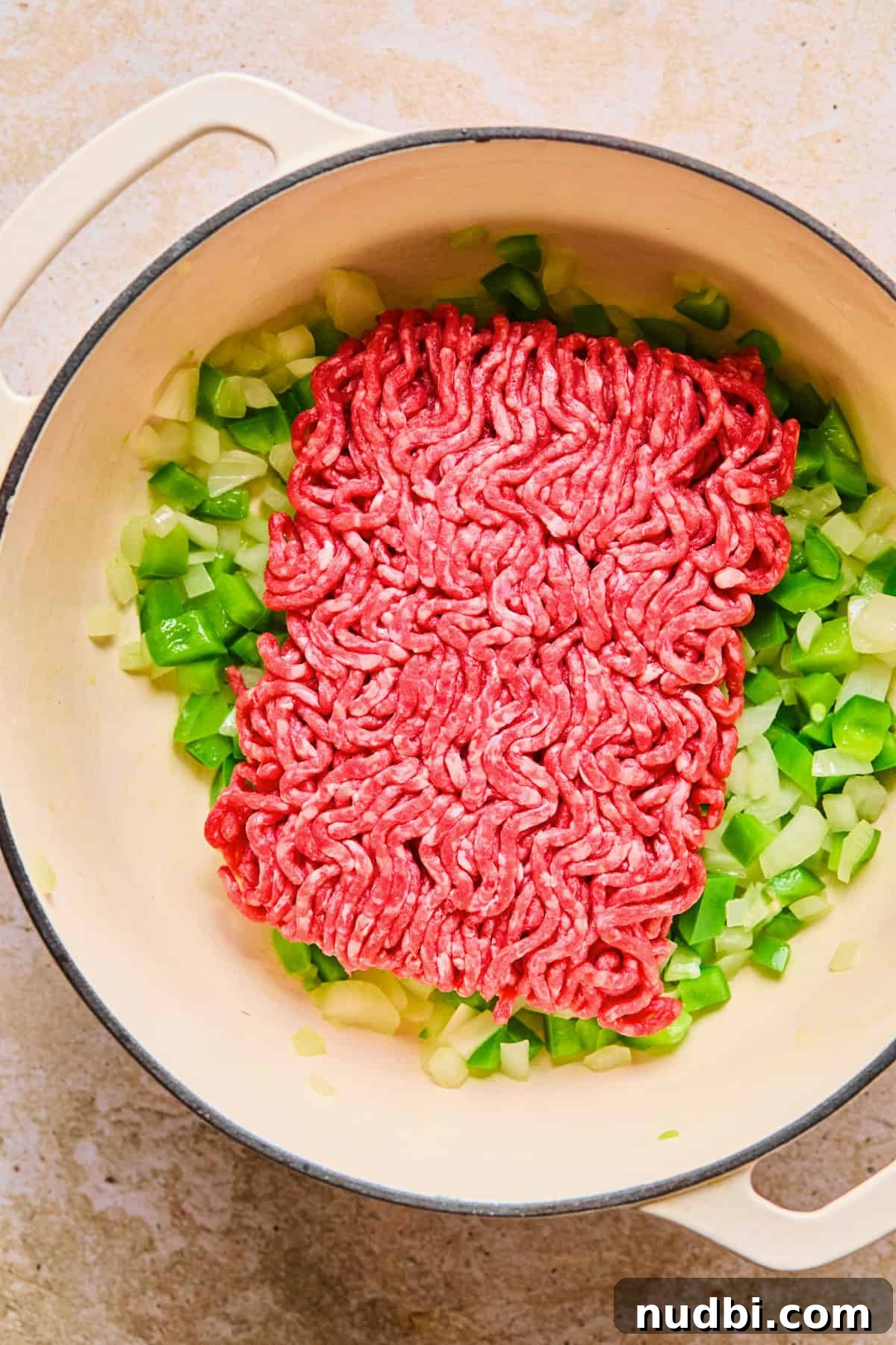 One-Pot Chili Mac: Cheesy Beef Skillet Dinner 6 Pound of ground beef added to pot with onion and pepper.