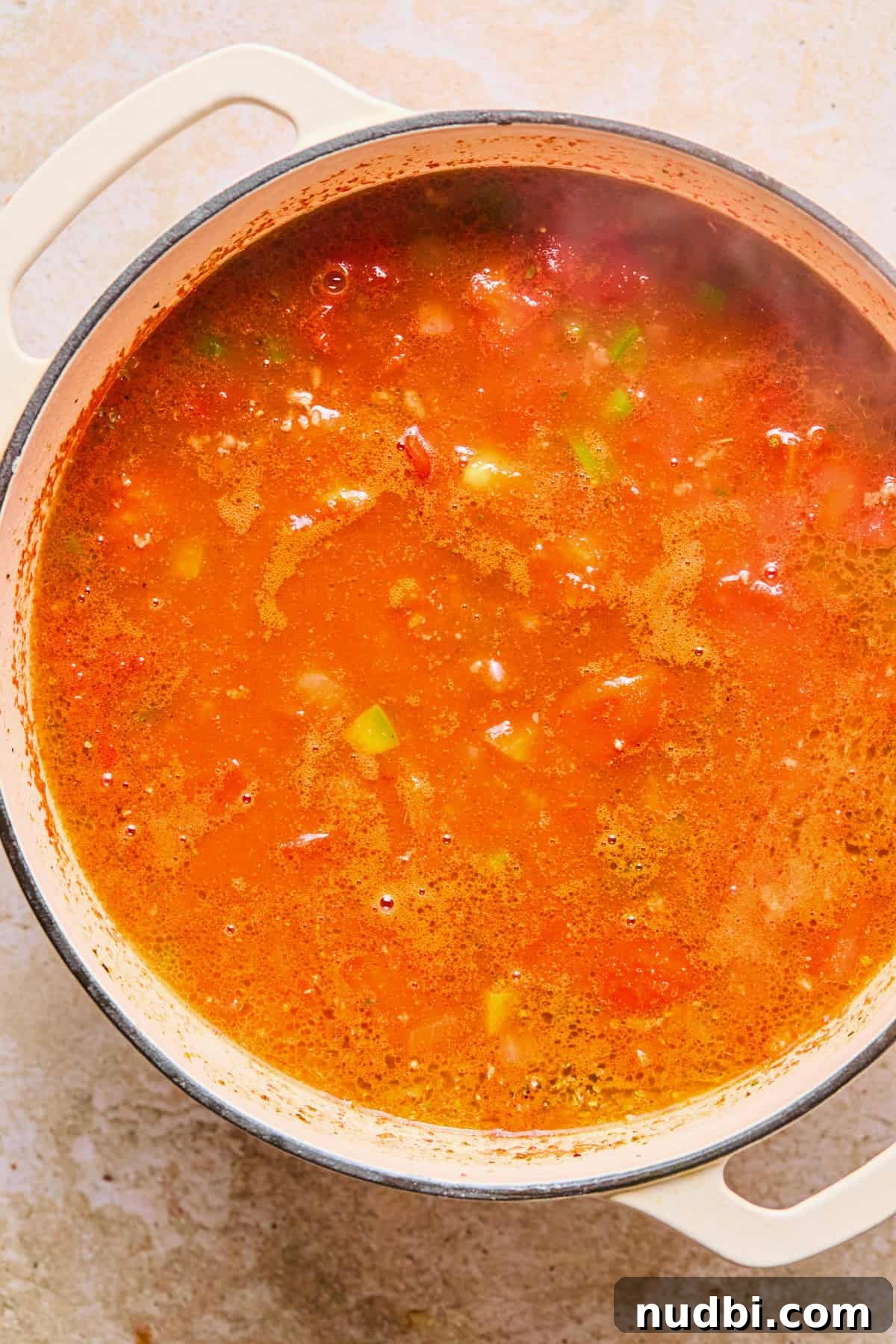 One-Pot Chili Mac: Cheesy Beef Skillet Dinner 9 Simmering broth and spices in pot.