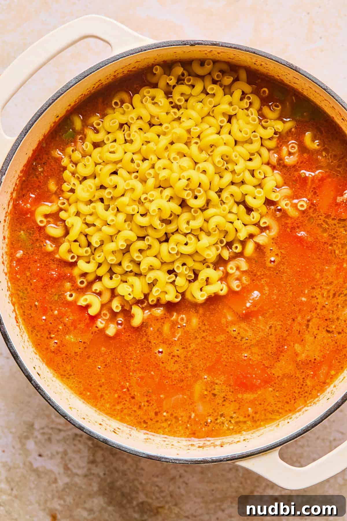 One-Pot Chili Mac: Cheesy Beef Skillet Dinner 10 Elbow macaroni added to pot of chili.