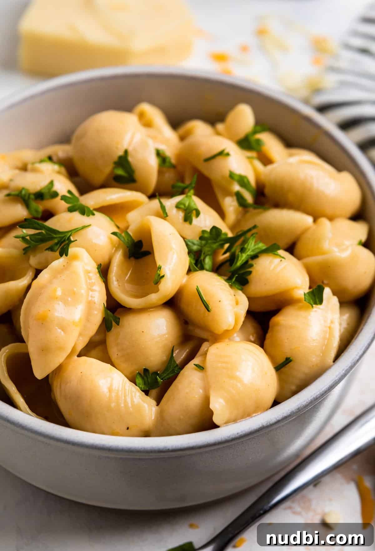 Creamy Instant Pot Mac and Cheese in 15 Minutes 2 Bowl of instant pot mac and cheese shells with chopped parsley on top.