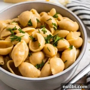 Creamy Instant Pot Mac and Cheese in 15 Minutes 7 Creamy macaroni and cheese shells in clay bowl with chopped fresh parsley on top.