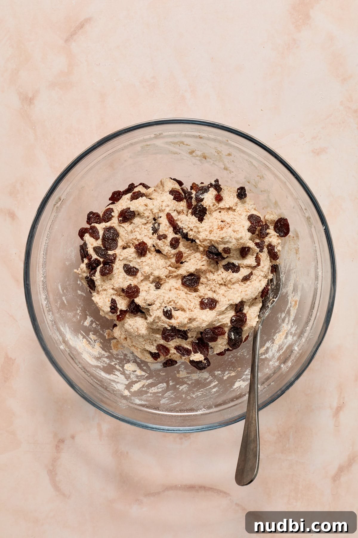 Cinnamon Raisin Bagel Recipe: Homemade Soft Chewy Bagels 7 Raisins added to the bagel dough with spoon in bowl.