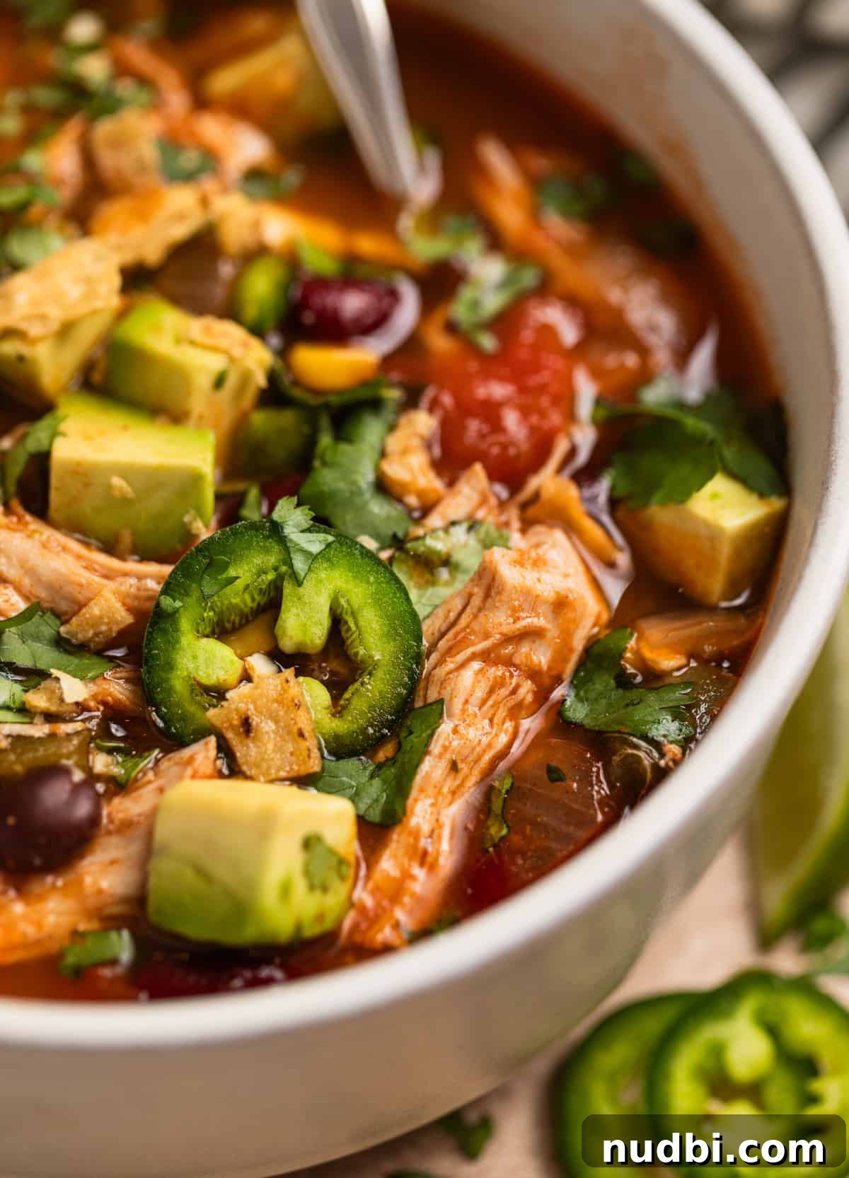 Instant Pot Chicken Tortilla Soup Recipe 3 Bowl with chicken tortilla soup and spoon scooping into the bowl.