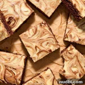Kahlúa Cream Cheese Brownies Recipe — Luscious Coffee-Chocolate Swirl 15 Kahlua brownies with cheesecake swirls on top sliced and arranged on parchment.