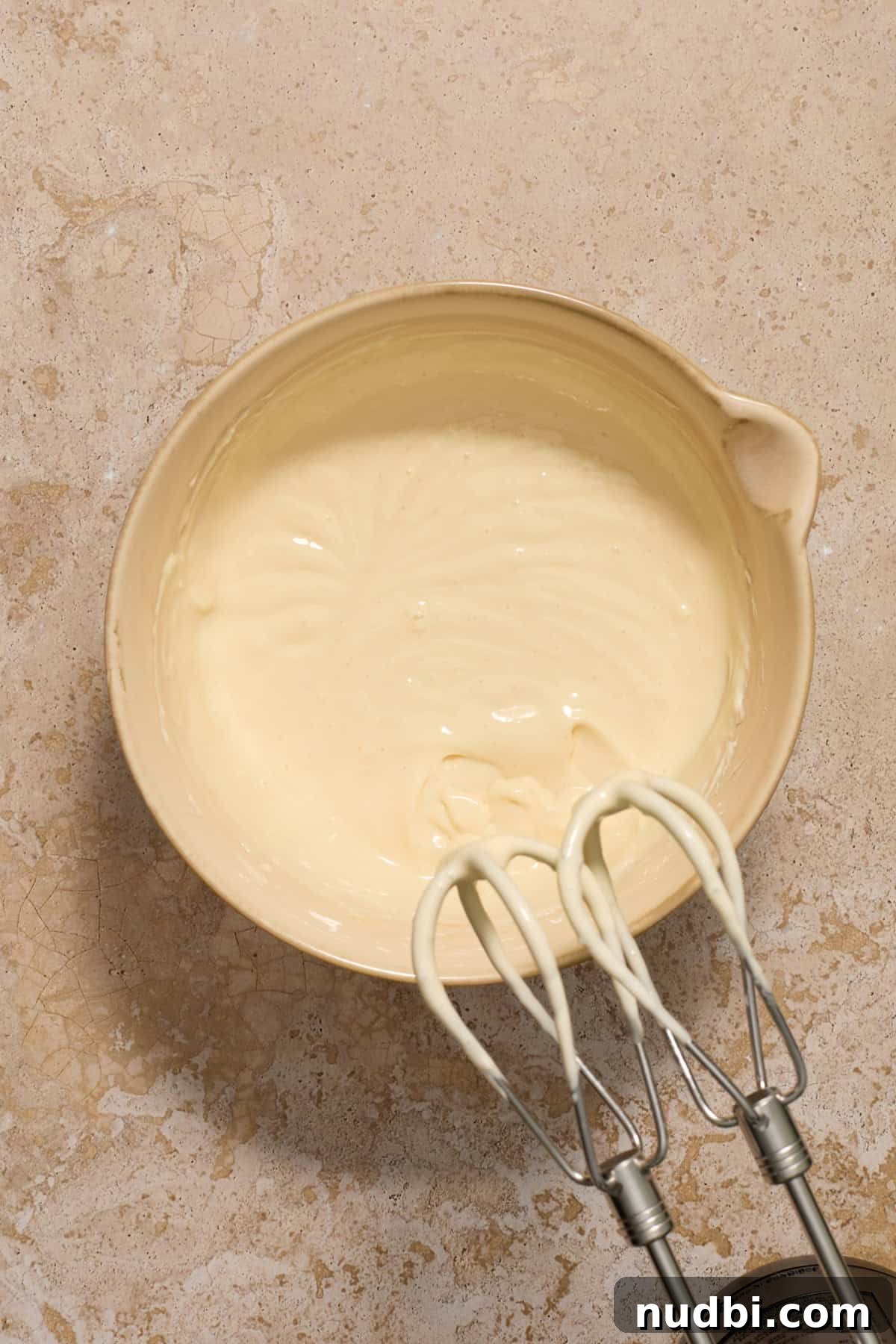Kahlúa Cream Cheese Brownies Recipe — Luscious Coffee-Chocolate Swirl 7 Cheesecake mixture in mixing bowl with electric mixer.