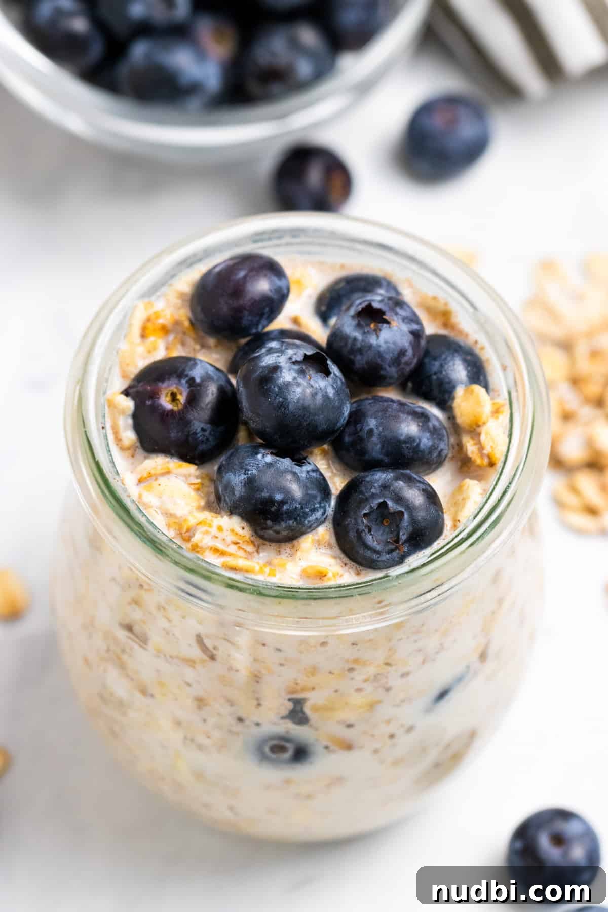 Blueberry Muffin Overnight Oats Recipe for Quick Morning Meals 2 Blueberry overnight oats in glass jar with blueberries on top.