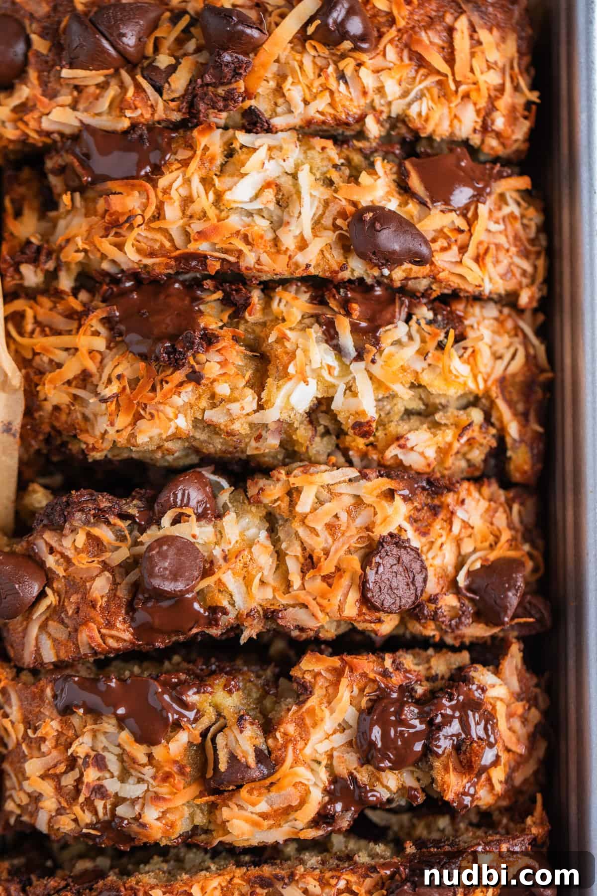 Coconut Banana Chocolate Chip Bread Recipe 11 Slices of coconut topped banana bread with dark chocolate chips on top.