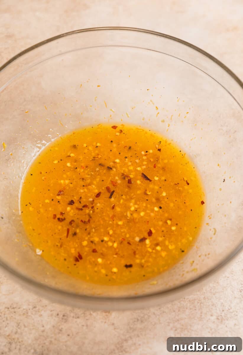 Sticky Orange Sheet Pan Chicken Dinner 5 Orange chicken marinade in glass mixing bowl.