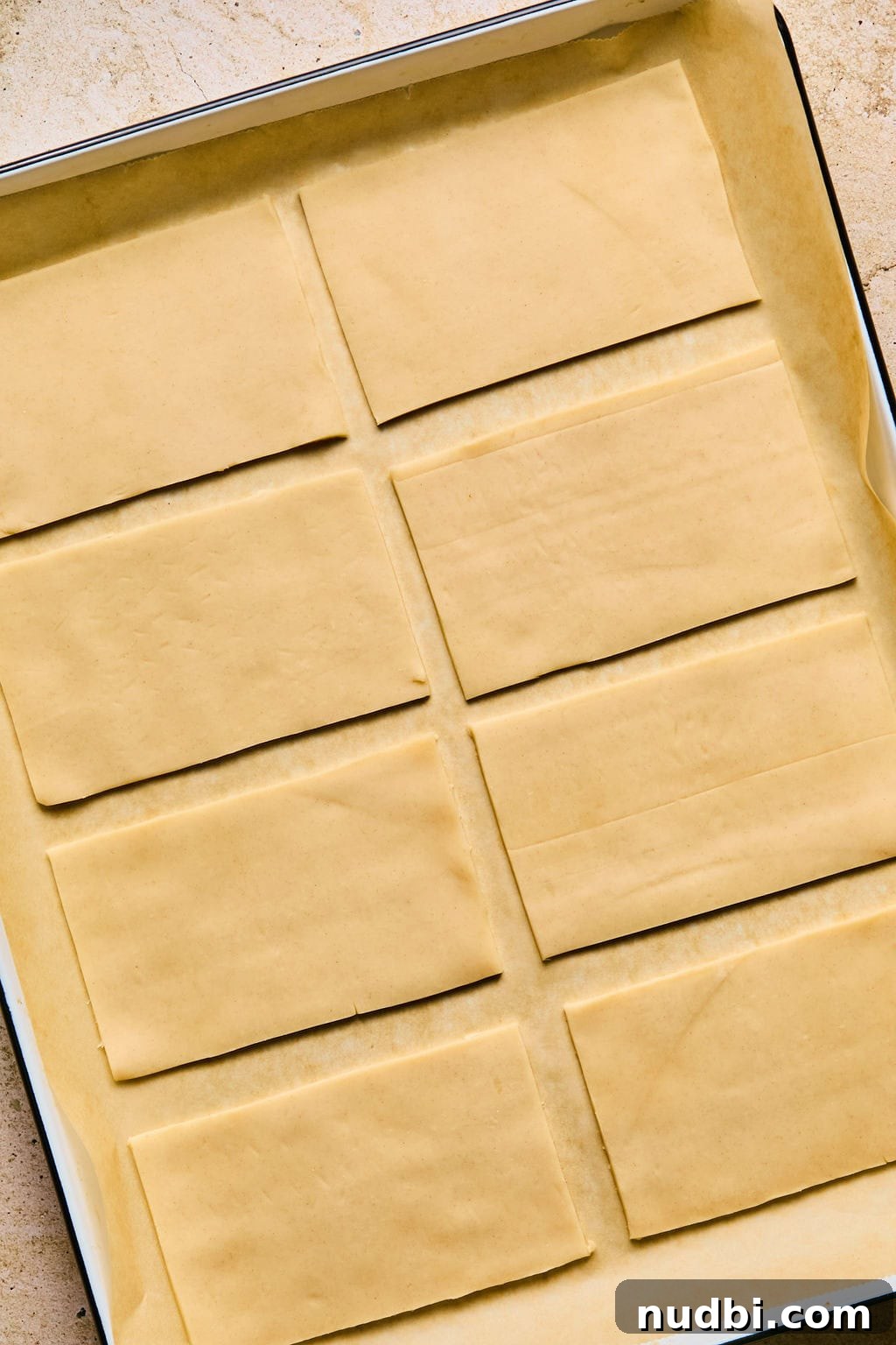 Homemade Pop-Tarts Made with Flaky Pie Crust — Sweet Breakfast Pastry 7 Parchment lined cookie sheet with rectangles of pie crust.