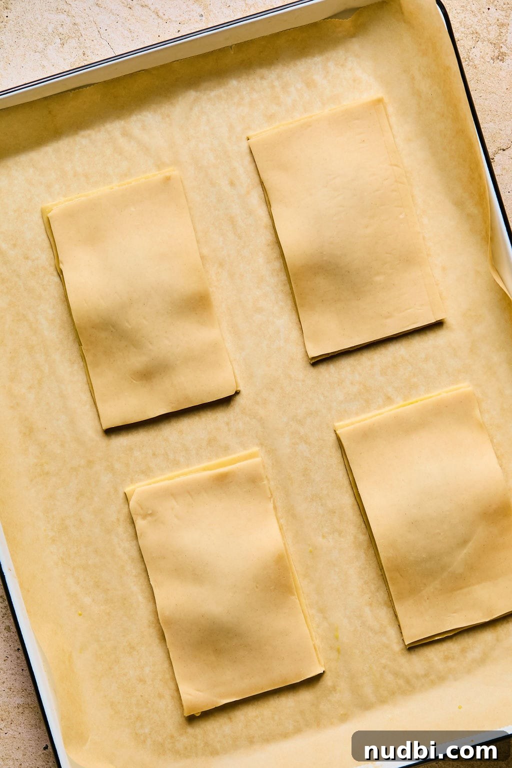 Homemade Pop-Tarts Made with Flaky Pie Crust — Sweet Breakfast Pastry 10 Top layer of pie crust added to homemade pop tarts on baking sheet.