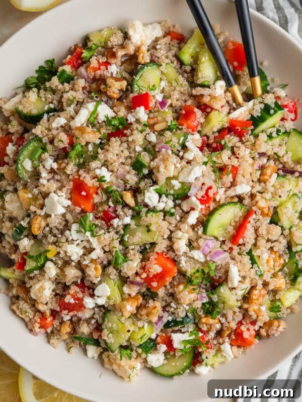 Spring Green Burrata Salad with Lemon Herb Vinaigrette 13 Cucumber quinoa salad in bowl with peppers, feta, chopped dill and serving utensils.
