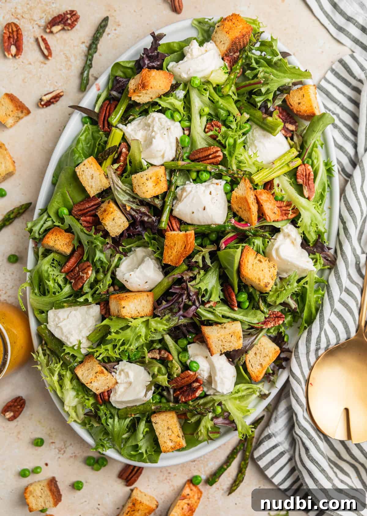 Spring Green Burrata Salad with Lemon Herb Vinaigrette 8 Burrata salad with croutons, pecans and asparagus on plate.