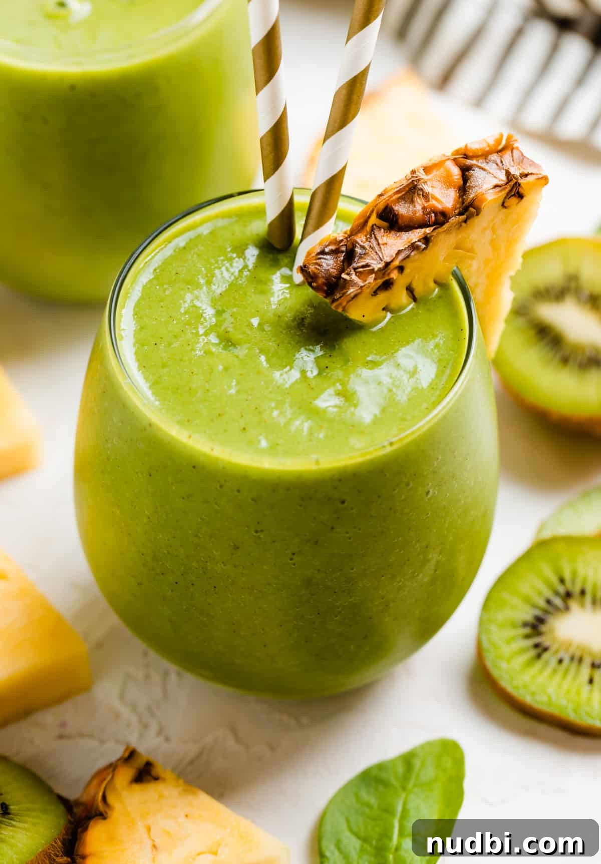 Pineapple Kiwi Smoothie Recipe for Fresh Morning Energy 2 Pineapple kiwi smoothie in glass with pineapple and kiwi slices.