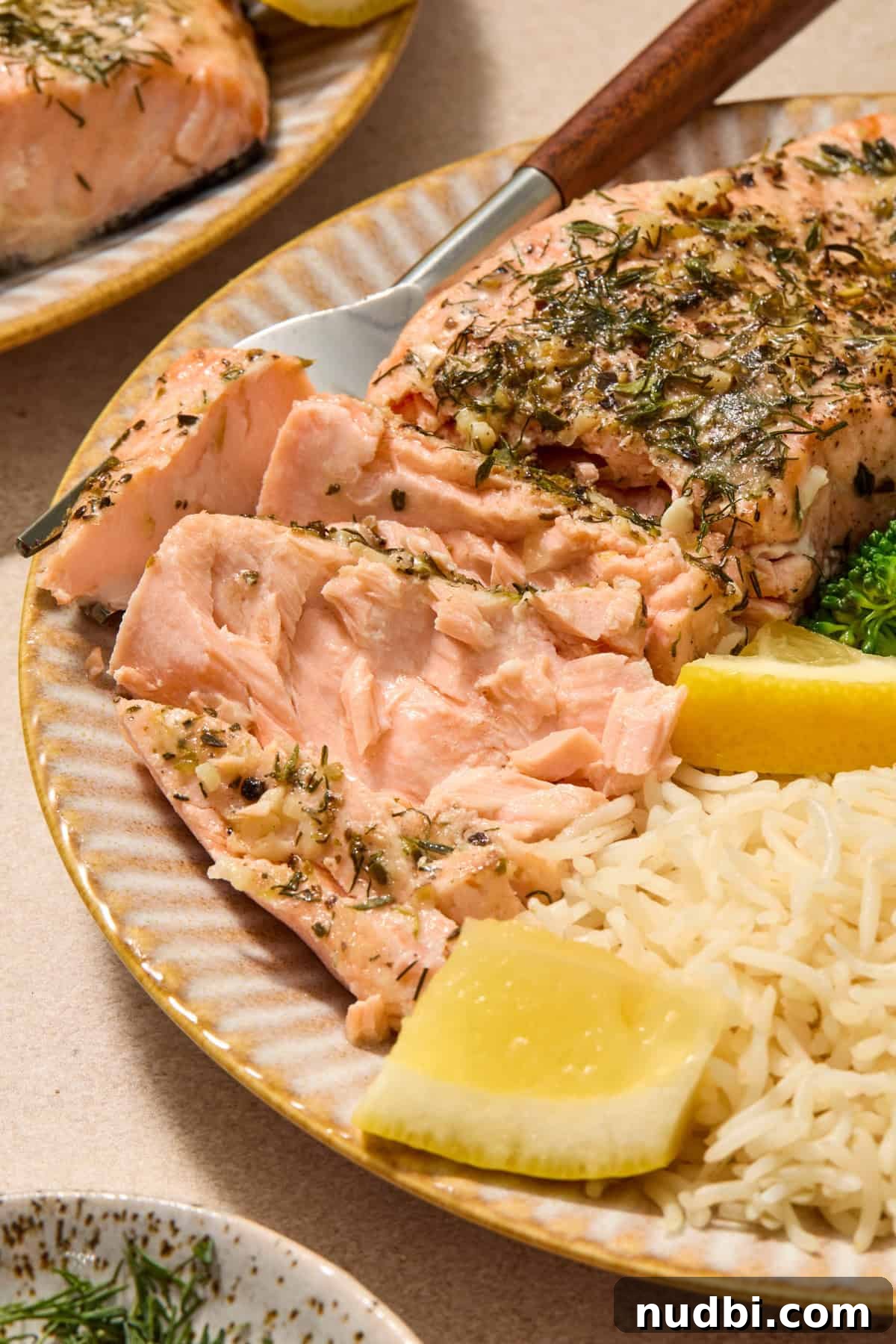 Instant Pot Butter Herb Salmon Recipe for Tender, Flaky Fish 8 Salmon flaked to show texture on plate with rice and lemon wedges.