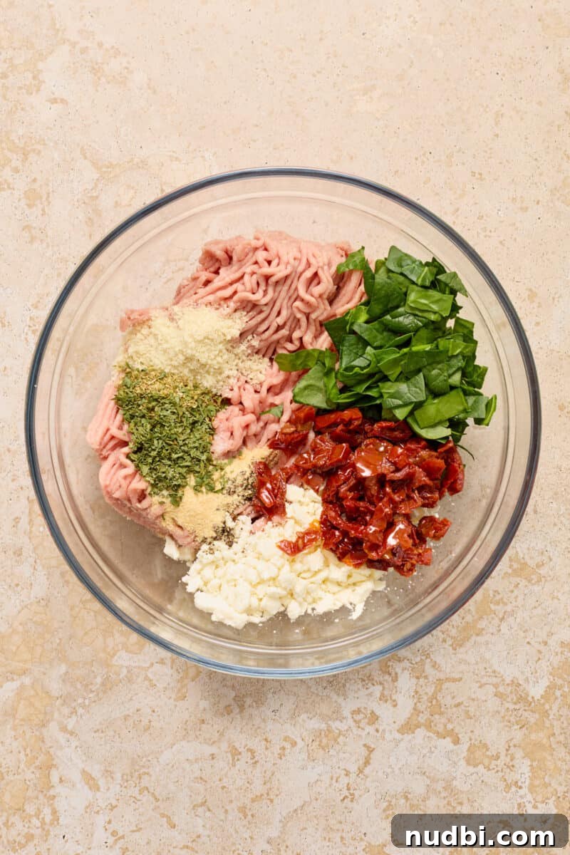Spinach and Feta Turkey Burgers with Garlic Yogurt Sauce 4 Ground turkey, spinach, feta, seasoning and other ingredients to make turkey burgers in glass bowl.