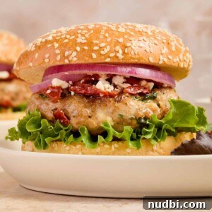 Spinach and Feta Turkey Burgers with Garlic Yogurt Sauce 10 Turkey burger with spinach and feta on bun with lettuce, onion and other ingredients.
