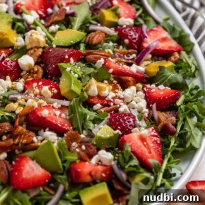 Strawberry and Goat Cheese Salad with Balsamic Glaze Recipe 6 Strawberry arugula goat cheese salad on white serving plate topped with balsamic dressing.