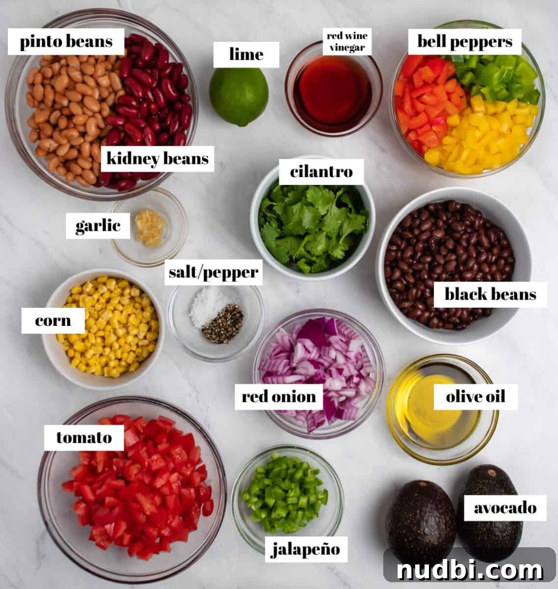 Southwestern Three-Bean, Corn & Avocado Salad Recipe 4 Peppers, beans, cilantro, avocado, corn and other ingredients labeled on counter.