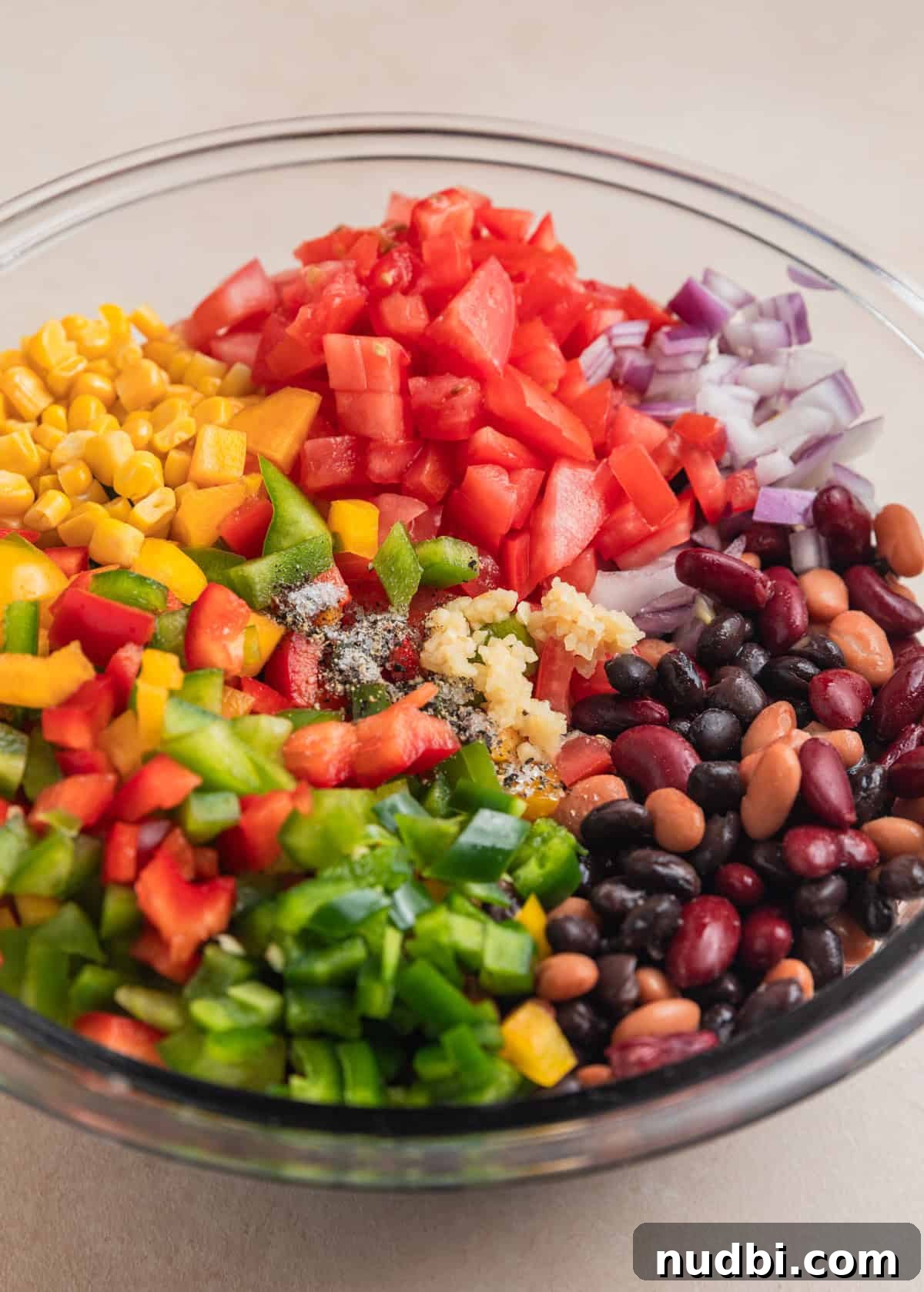 Southwestern Three-Bean, Corn & Avocado Salad Recipe 5 Diced tomatoes, pinto beans, black beans, kidney beans, chopped peppers and other ingredients in mixing bowl.