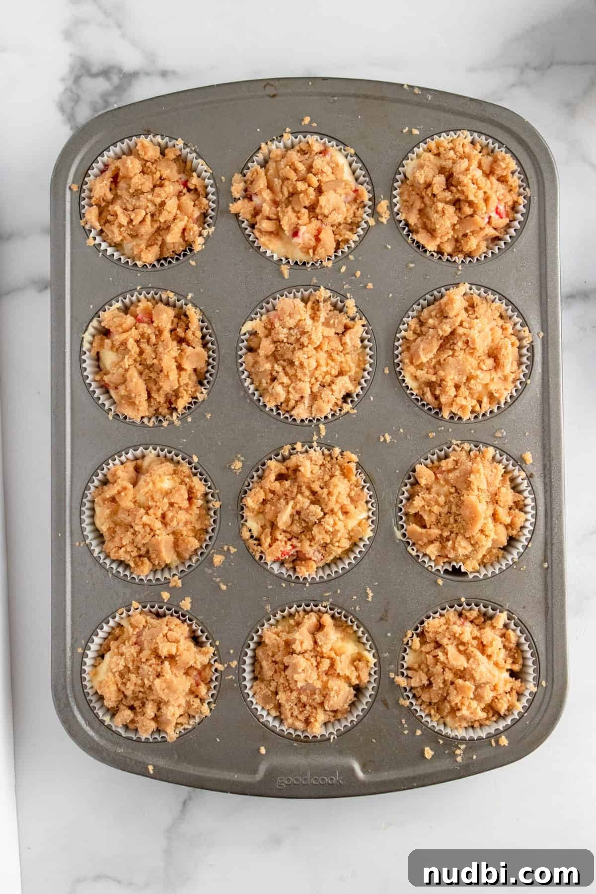 Strawberry Crumble Muffins: Moist Muffins with Crunchy Topping 12 Crumble topped strawberry muffins in muffin pan before baking.