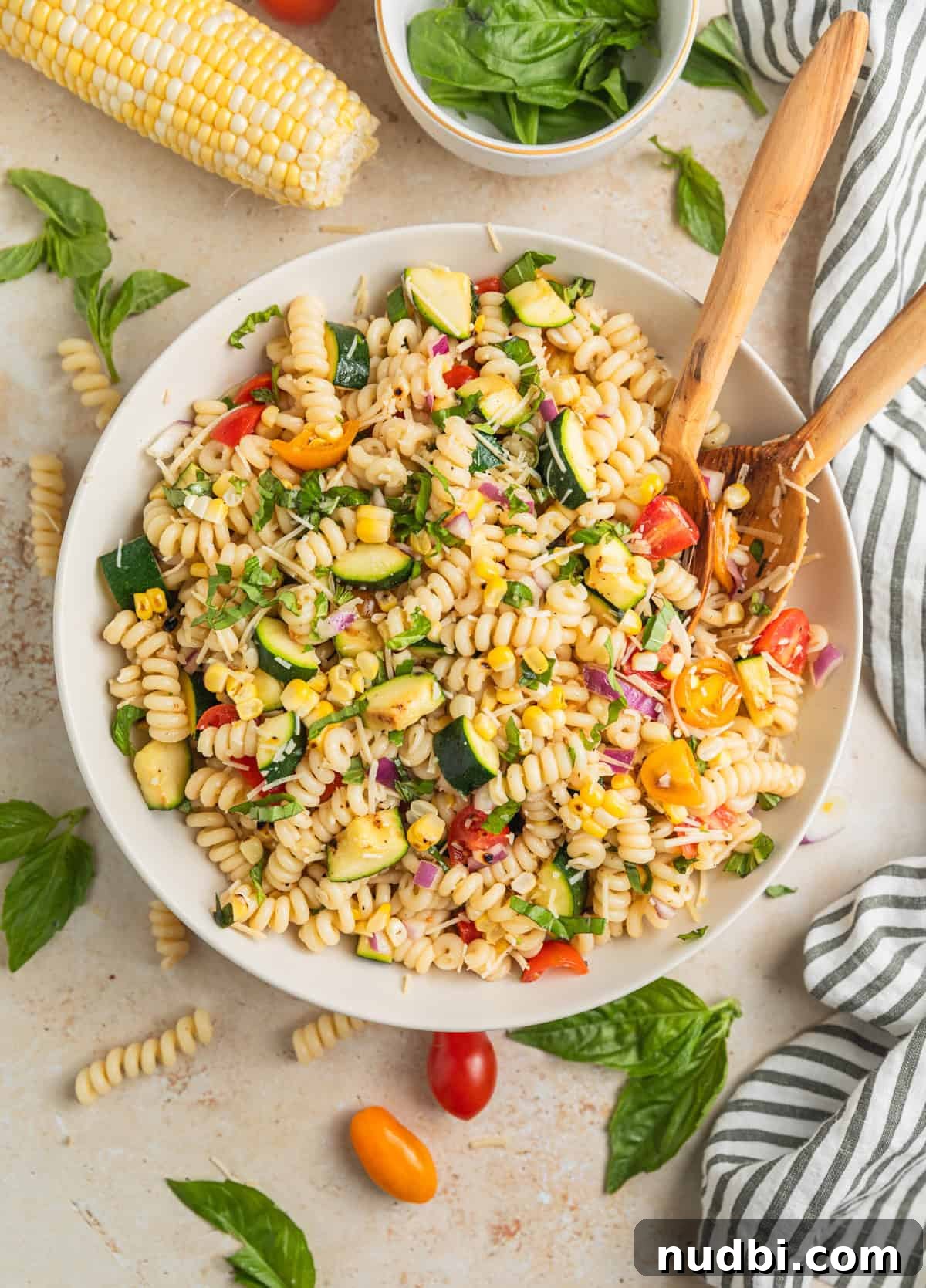 Grilled Zucchini Pasta Salad with Lemon Garlic Dressing 10 Overhead view of summer pasta salad with serving spoons in bowl.