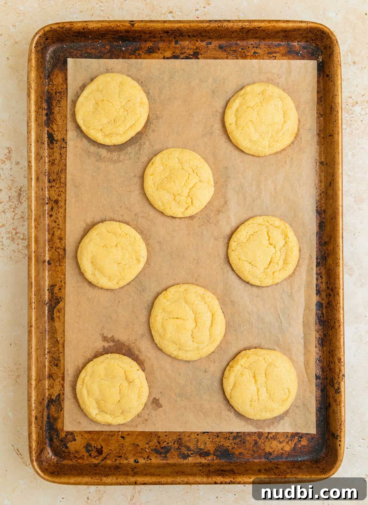 Zesty Lemon Sugar Cookies Recipe for Soft, Crispy Cookies 10 Baked lemon cookies fresh from oven on baking sheet.
