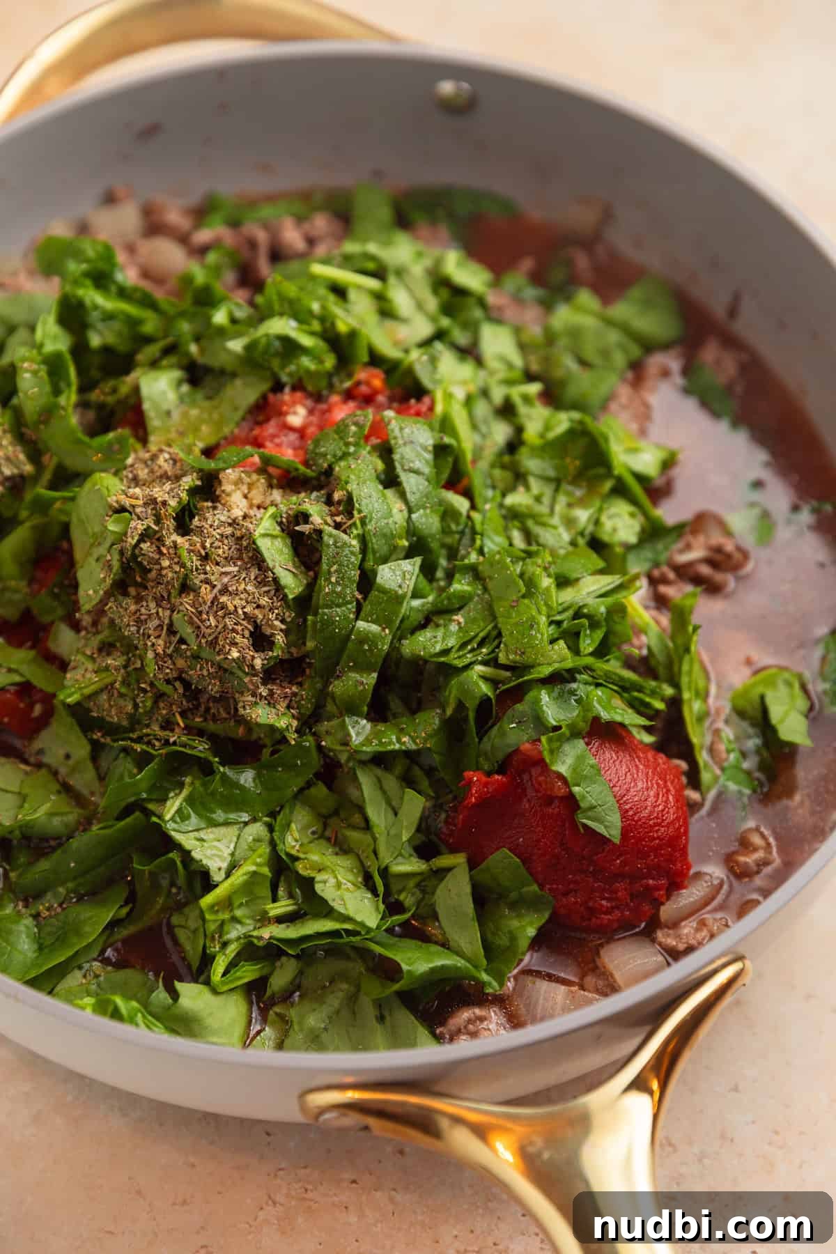One-Skillet Ground Beef Pasta Skillet Meal 5 Spinach, tomatoes, tomato sauce, and other ingredients added to beef in pan.